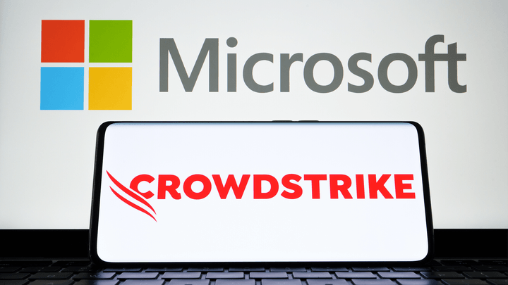 laptops saying Microsoft on screen in back and Crowdstrike in foreground