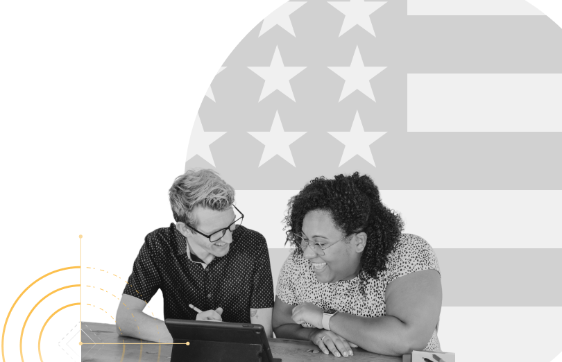 people looking at tablet in front of american flag