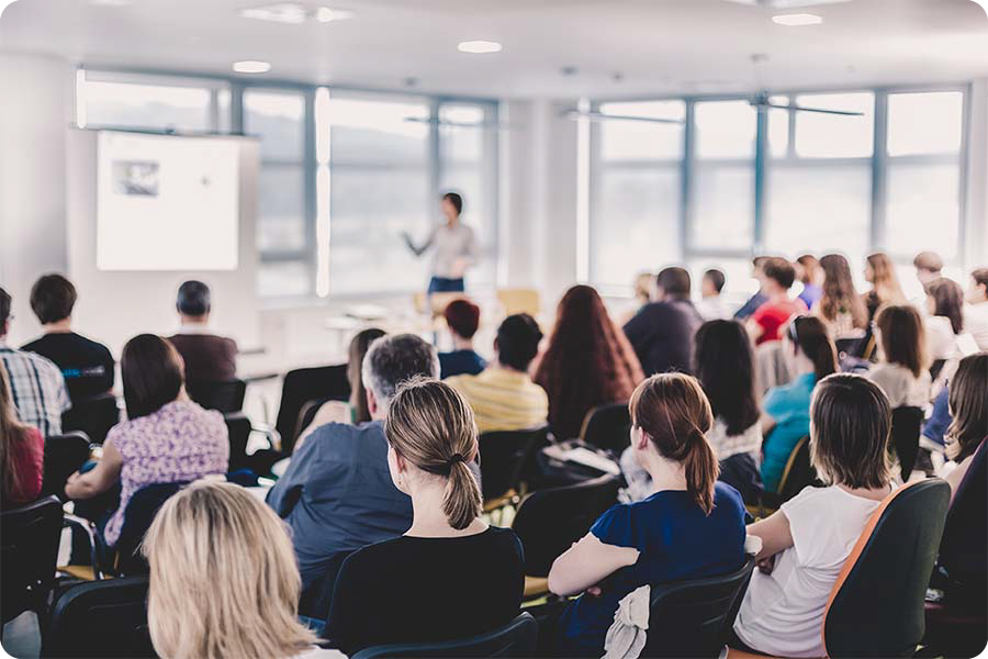 Private training image, person teaching in front of others in white room